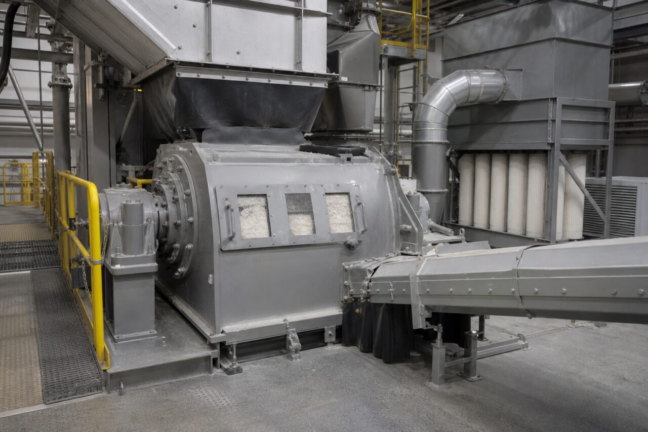 Grey machine beneath hopper with white sight windows