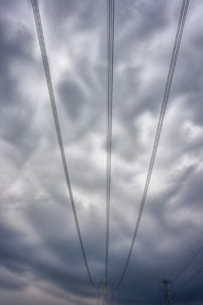 Conducteurs de haute tension et pylônes sous les nuages