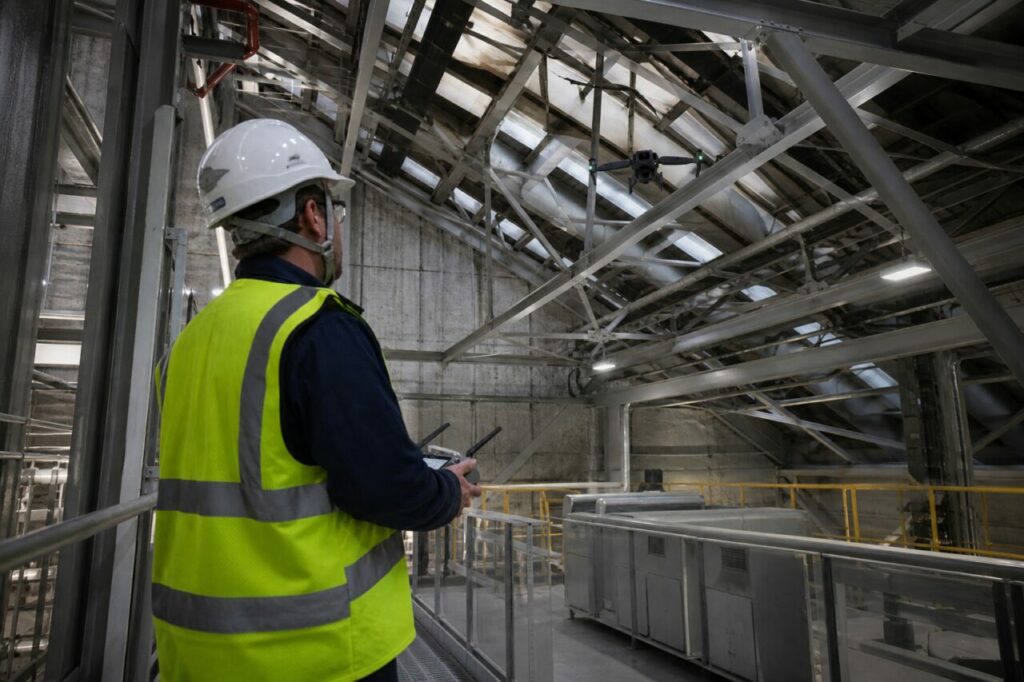 Drone inspection of an auxiliary-building roof — with multirotor drone beneath the beams