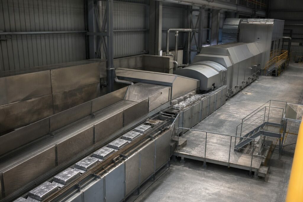 Lingots brillants sur convoyeur dans une ligne de coulée continue protégée du bismuth