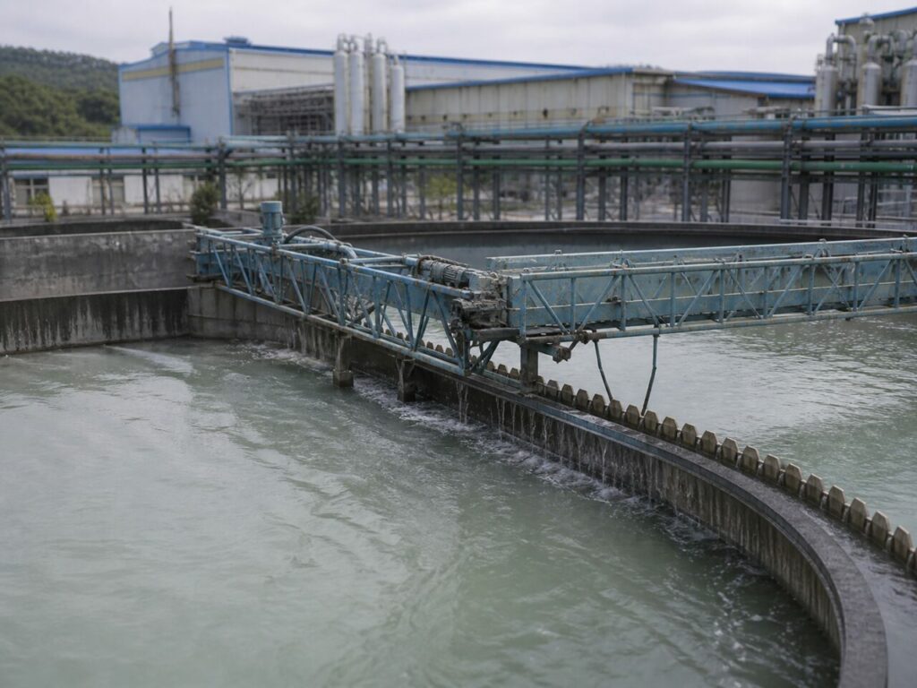 Pont racleur métallique au-dessus de l'eau en clarification industrielle
