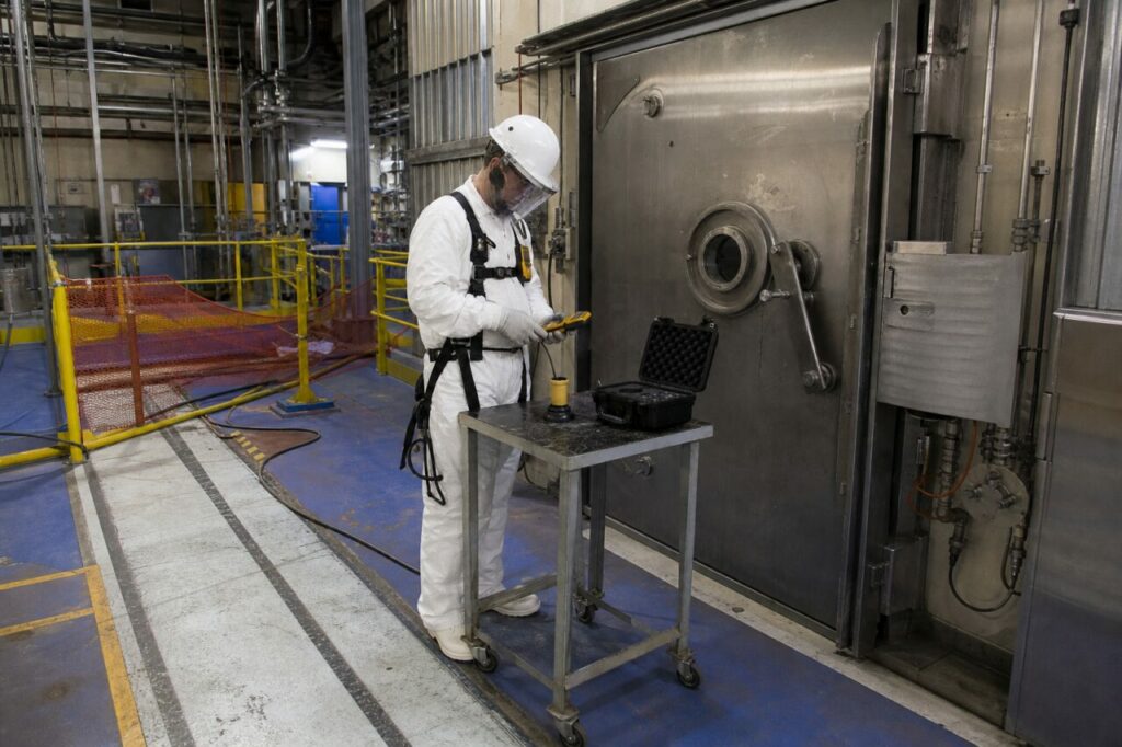 Porte blindée, chariot de mesure et garde-corps jaunes — Contrôle radiamétrique de sûreté en zone nucléaire