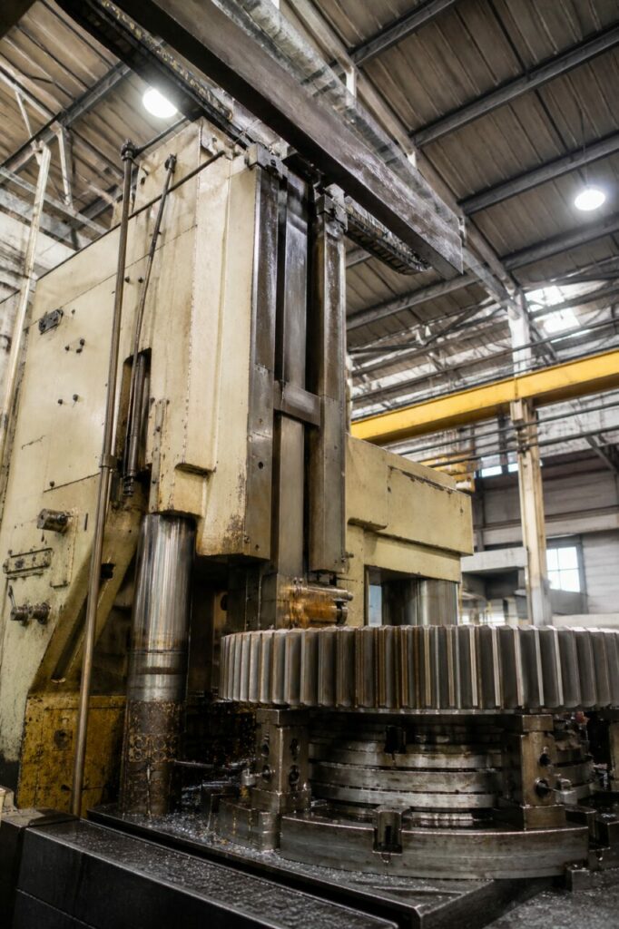 Tandwielsteekmachine bewerkt een industrieel rondsel, laag standpunt in de werkplaats